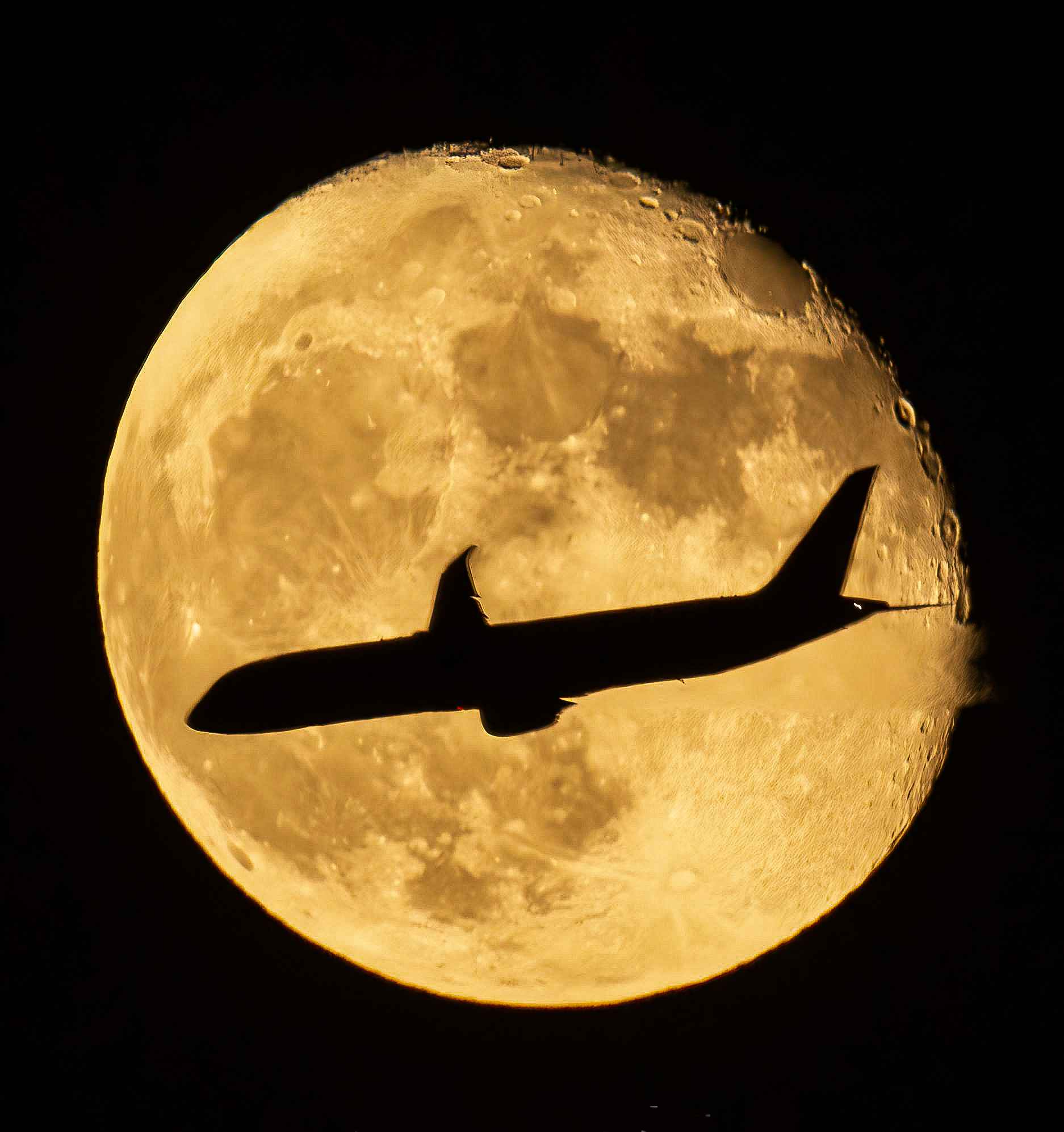 طائرة تعبر أمام القمر العملاق 